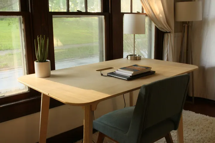 A plywood desk in front of a sunny window