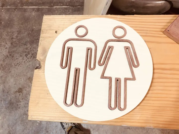 A finished round restroom sign