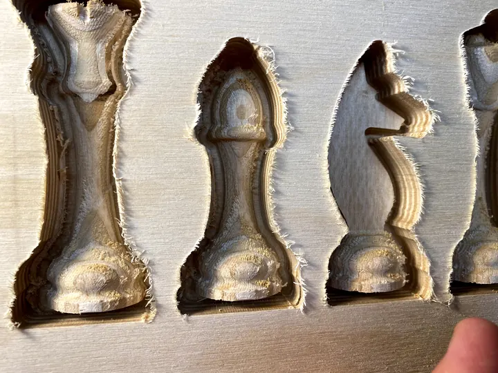 Chess pieces carved in relief, still in the block