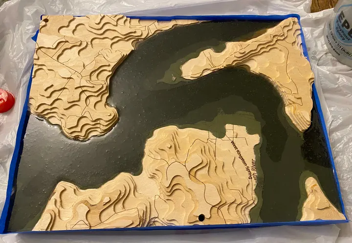 A carved relief map with a dark resin river